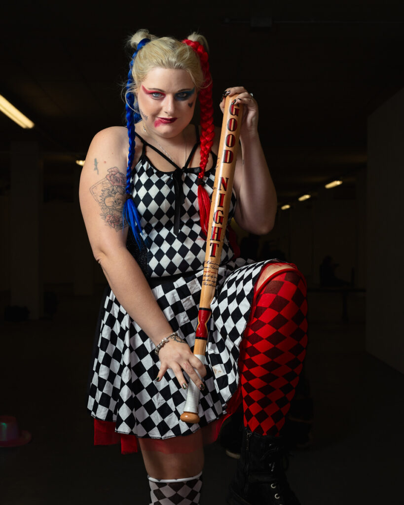 Woman dressed as Harley Quinn holding a wooden baseball bat