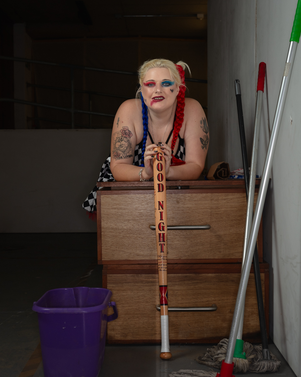 Woman with colourful braids posing with baseball bat