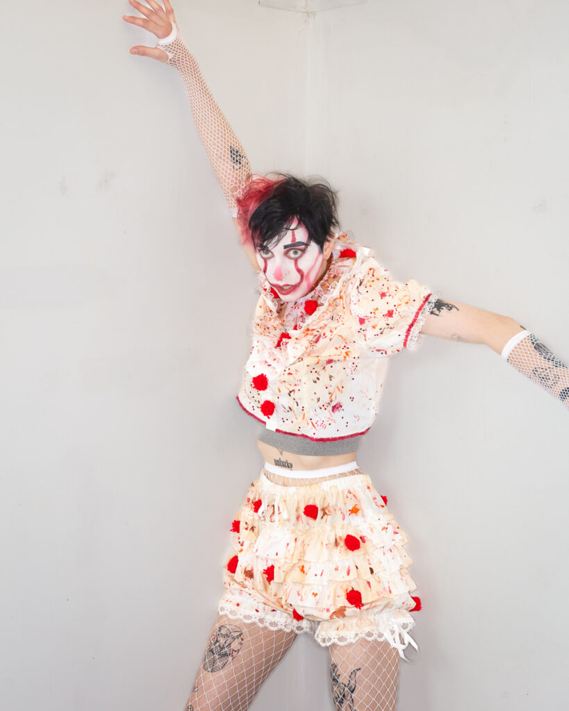 Person in theatrical clown makeup wearing splattered costume