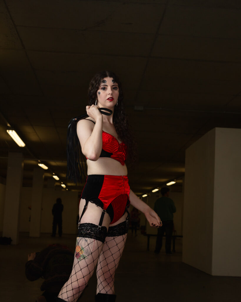 Woman in red and black lingerie posing in underground garage