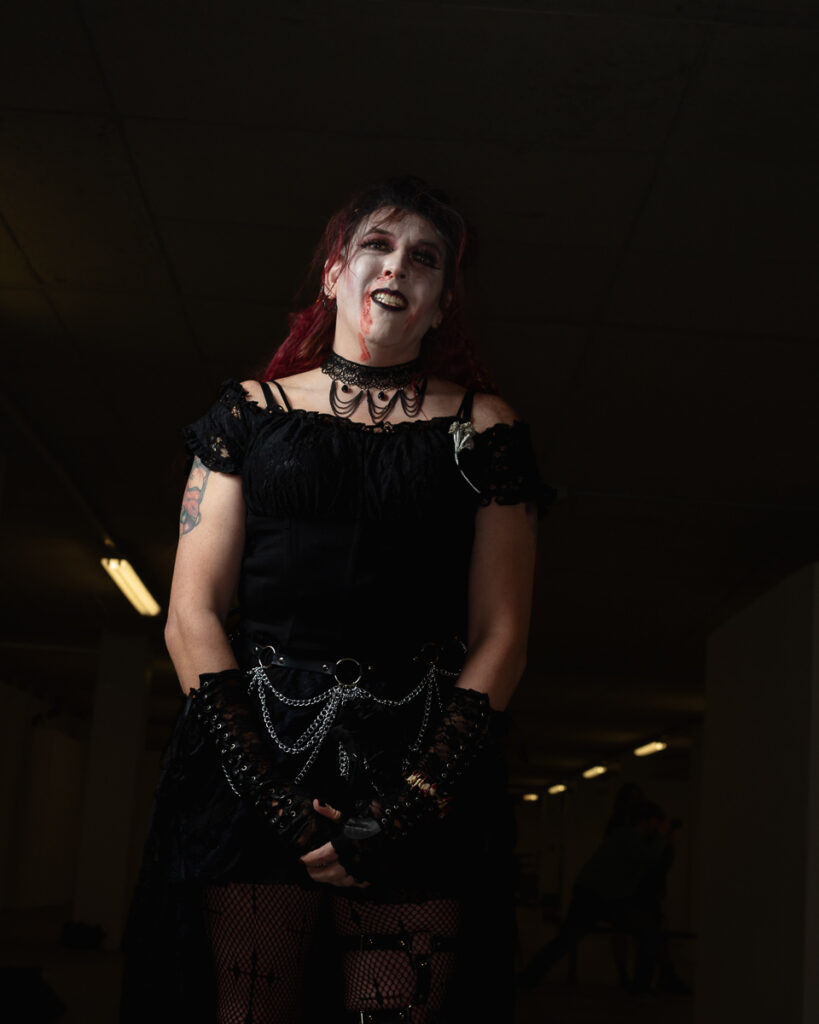 Person with red hair in gothic black outfit on stage