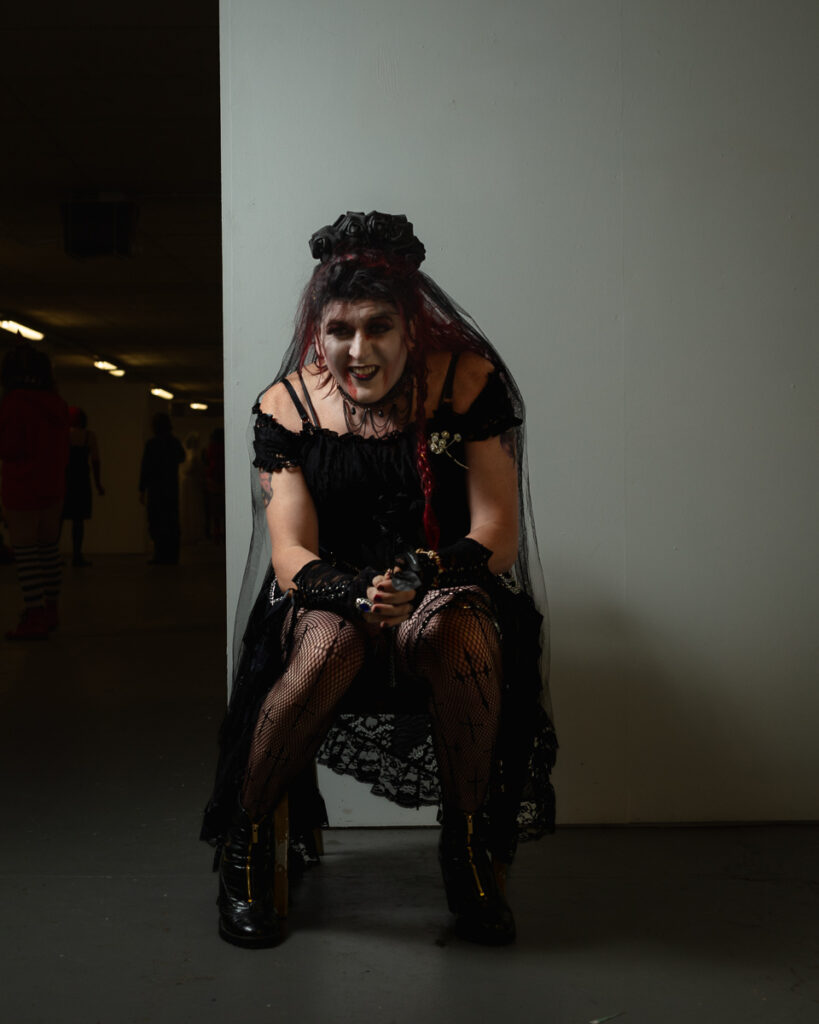 Woman in gothic black dress and veil costume smiling