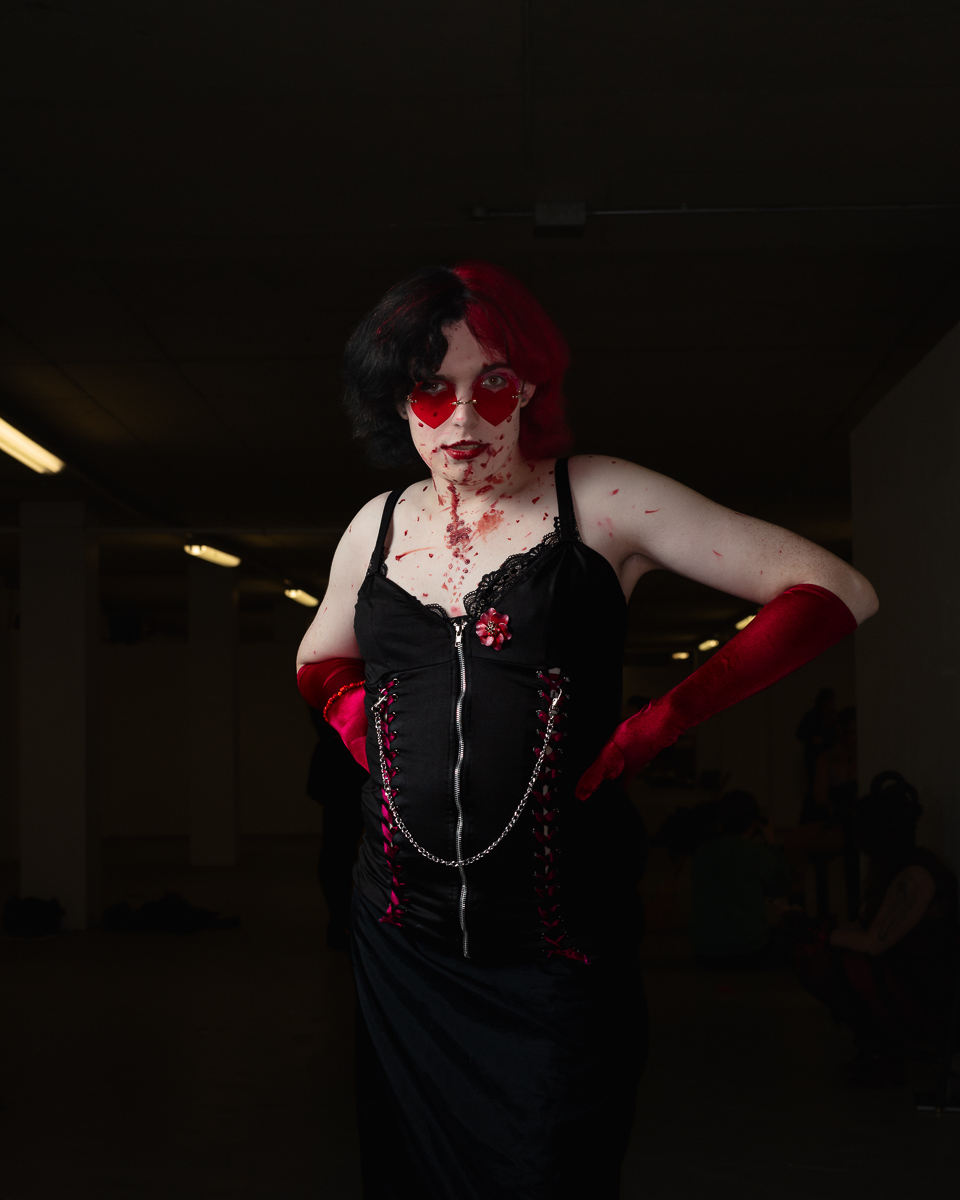 Person in gothic costume with heart-shaped red sunglasses