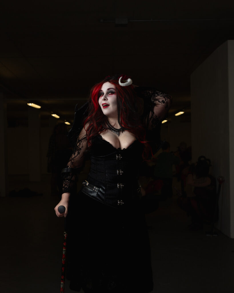 Woman with red hair in gothic black outfit and horns