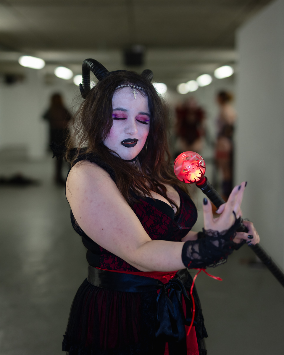 Woman in gothic demon costume holding glowing red orb