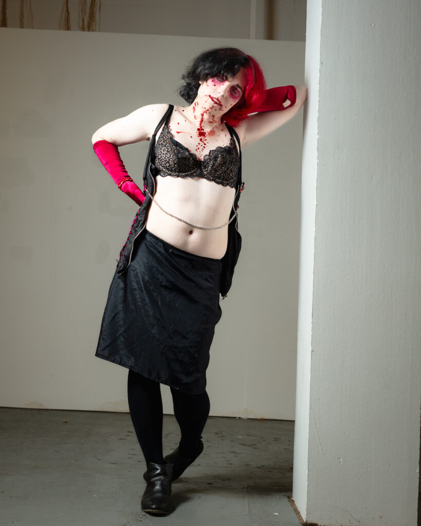 Woman in edgy fashion pose with red gloves and makeup