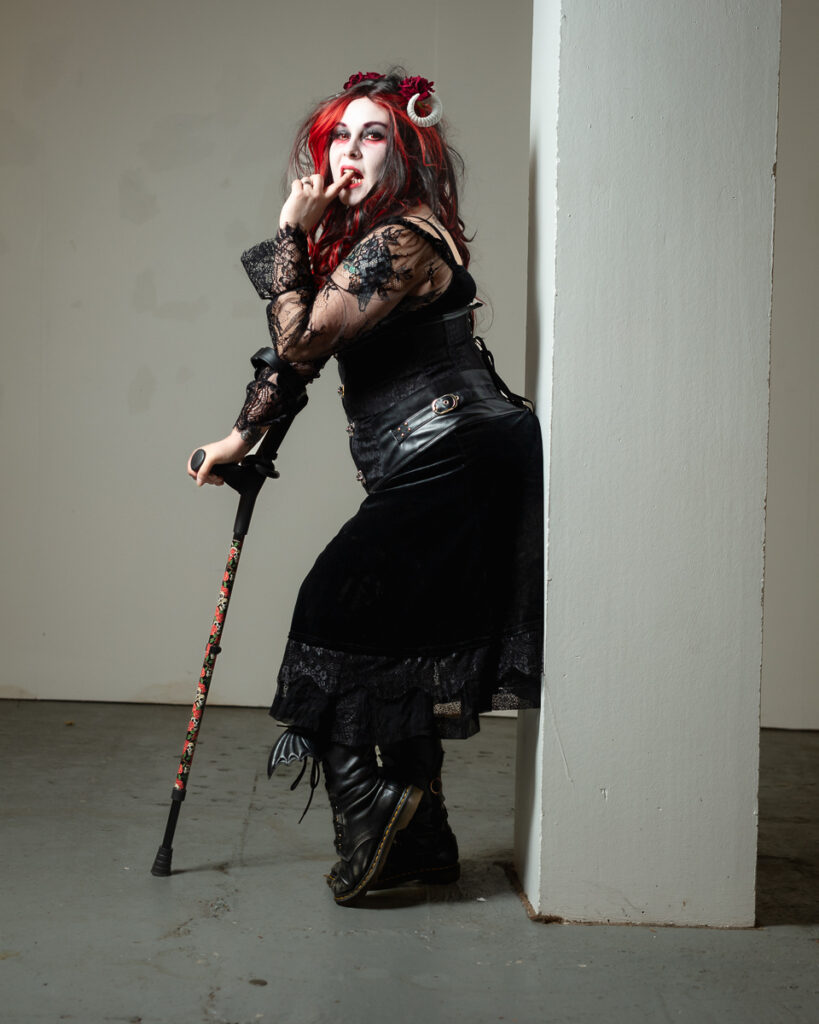 Gothic woman with red hair holding ornate cane staff