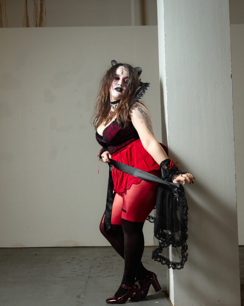 Person in gothic costume with red and black dress, cat ears