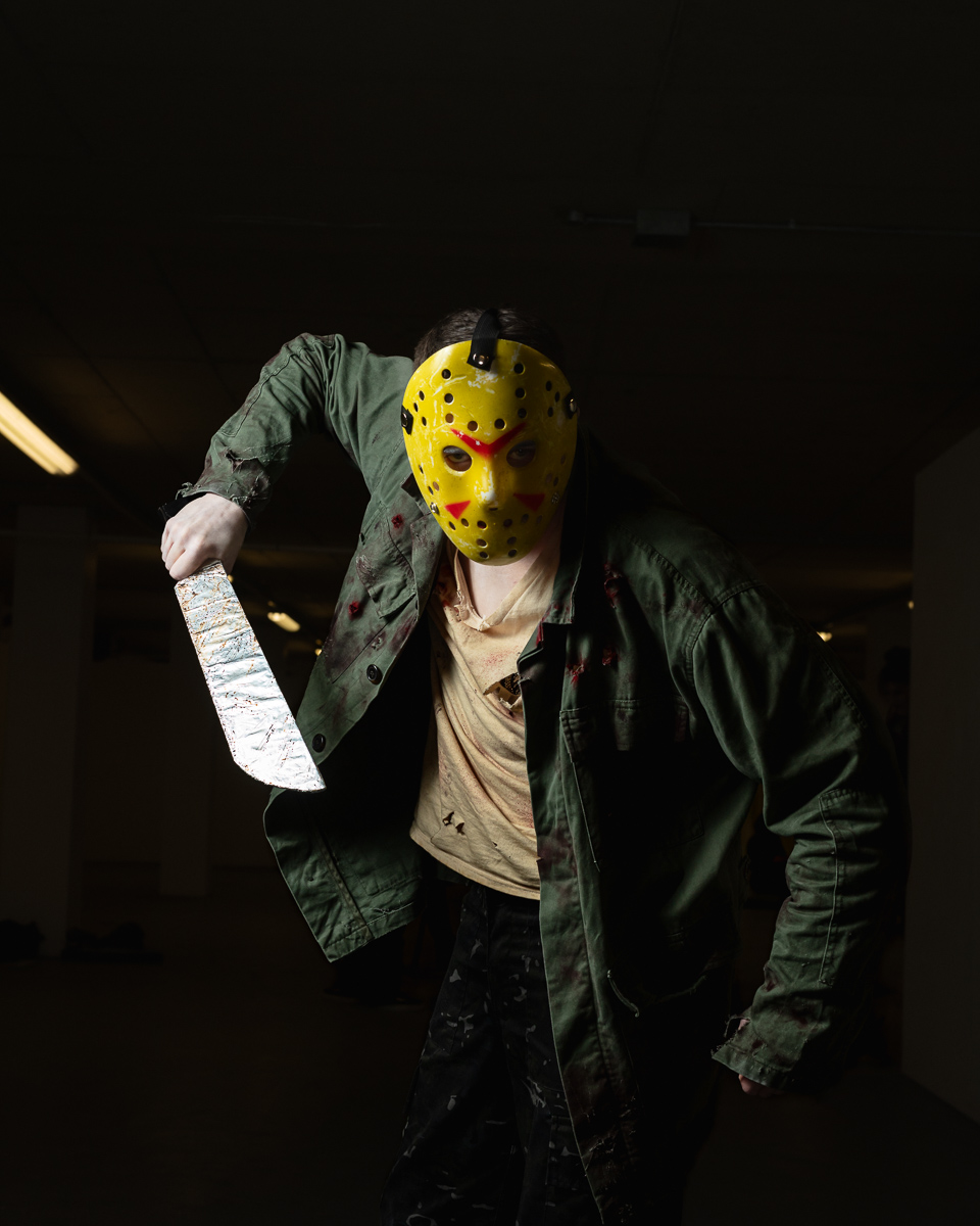 Person wearing yellow horror mask holding bloody knife