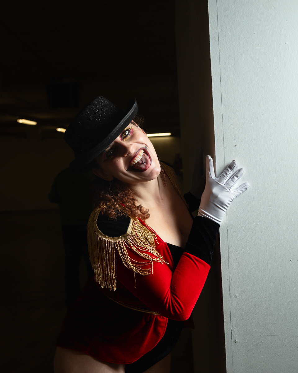 Performer in red jacket, top hat, and white gloves smiling