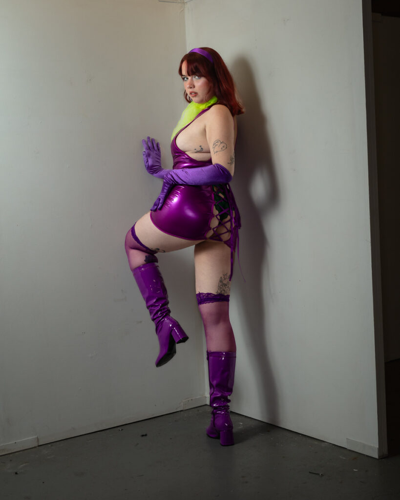 Woman in vibrant purple latex costume with neon green accents