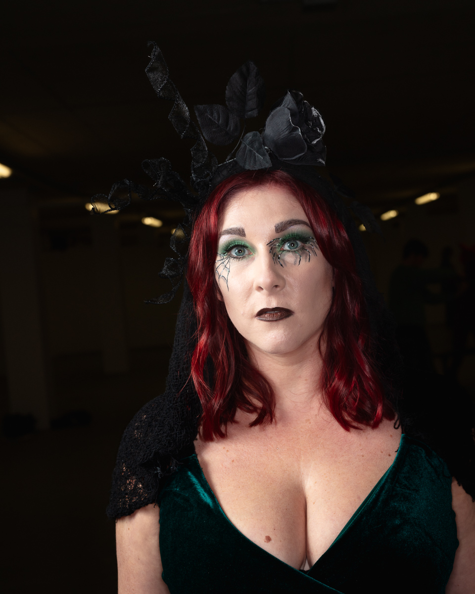 Woman with red hair wearing gothic makeup and black headpiece