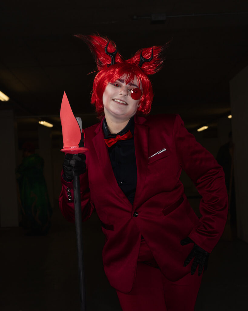 Person in red cosplay costume with horns and sword