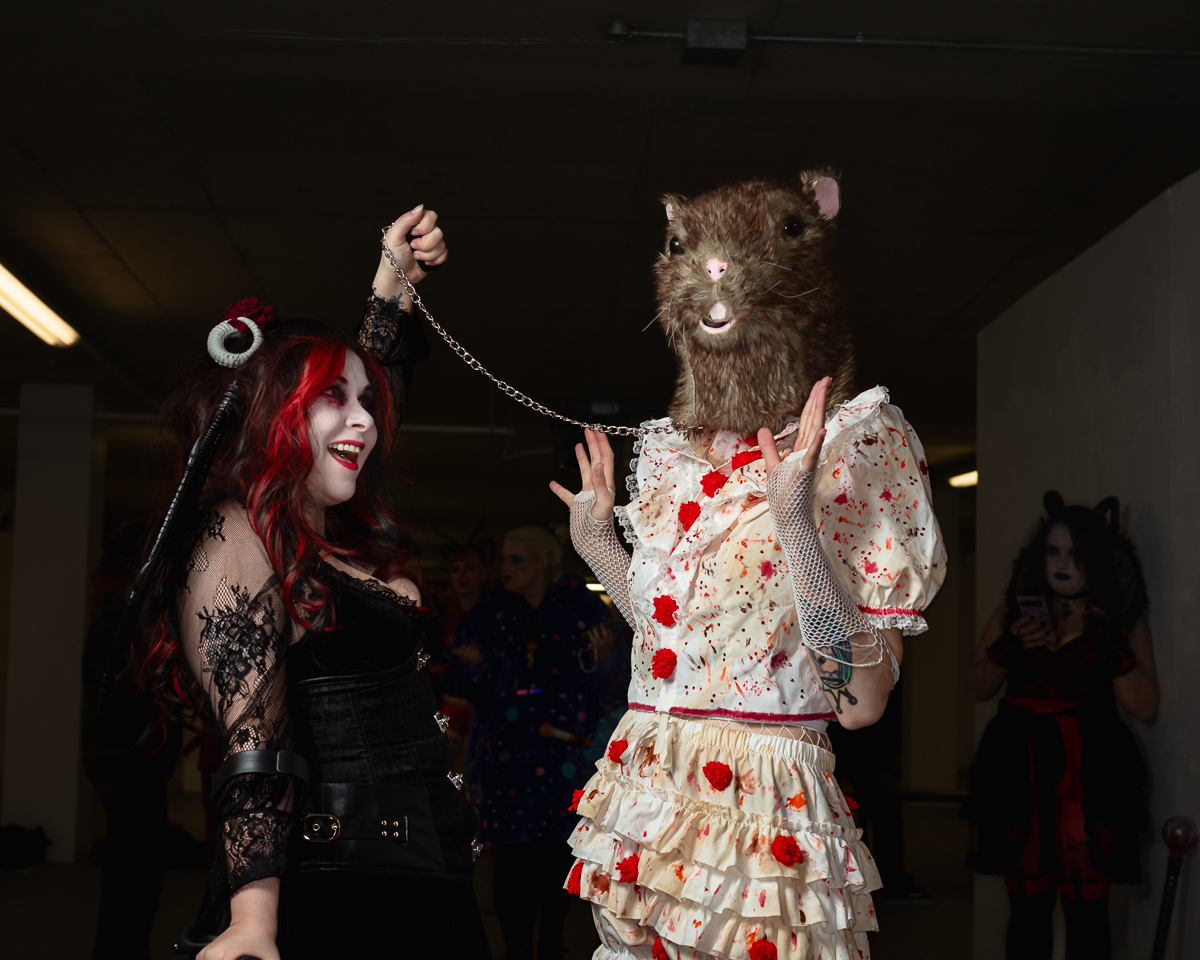 People in Halloween costumes, one with animal mask.