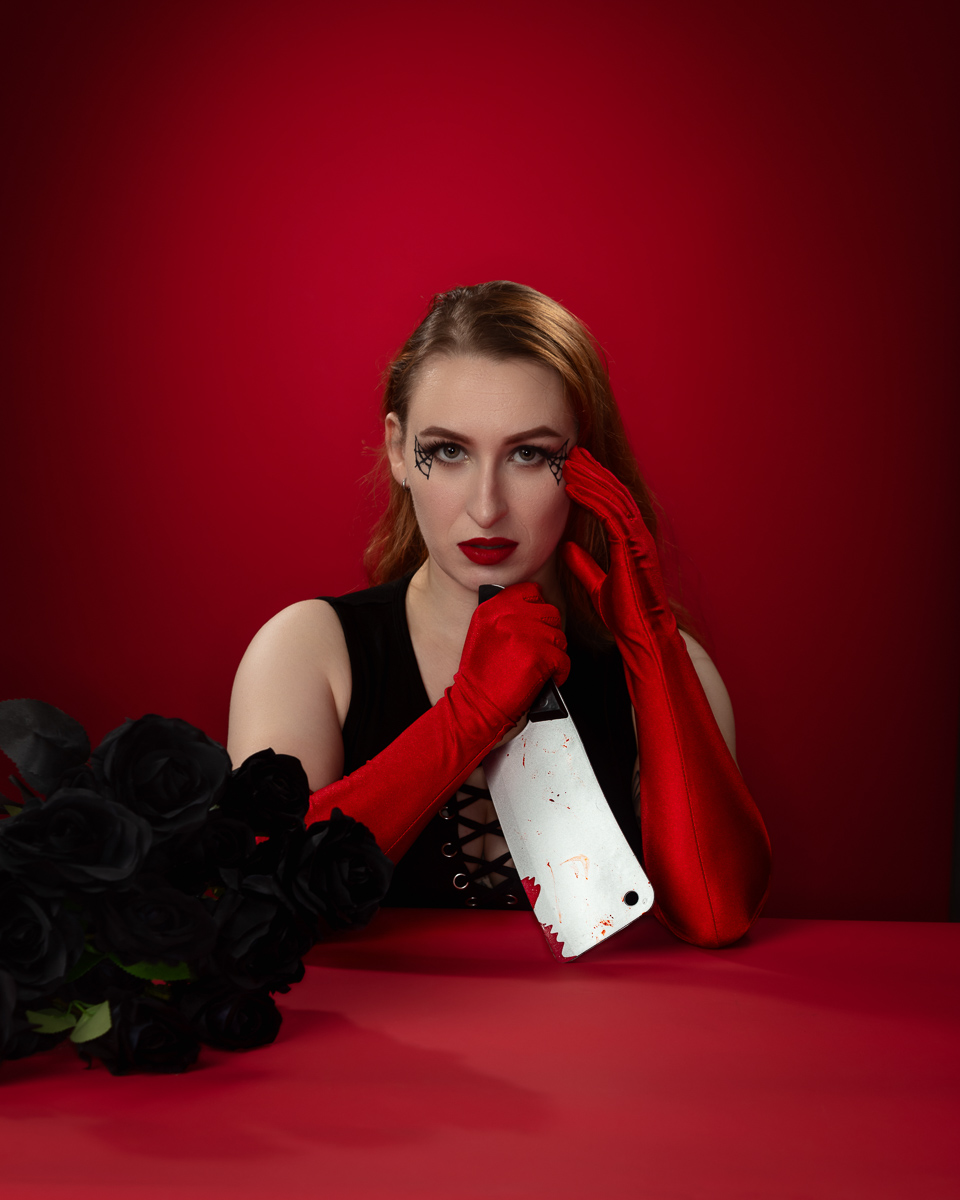 Woman in red gloves holding white card against red background