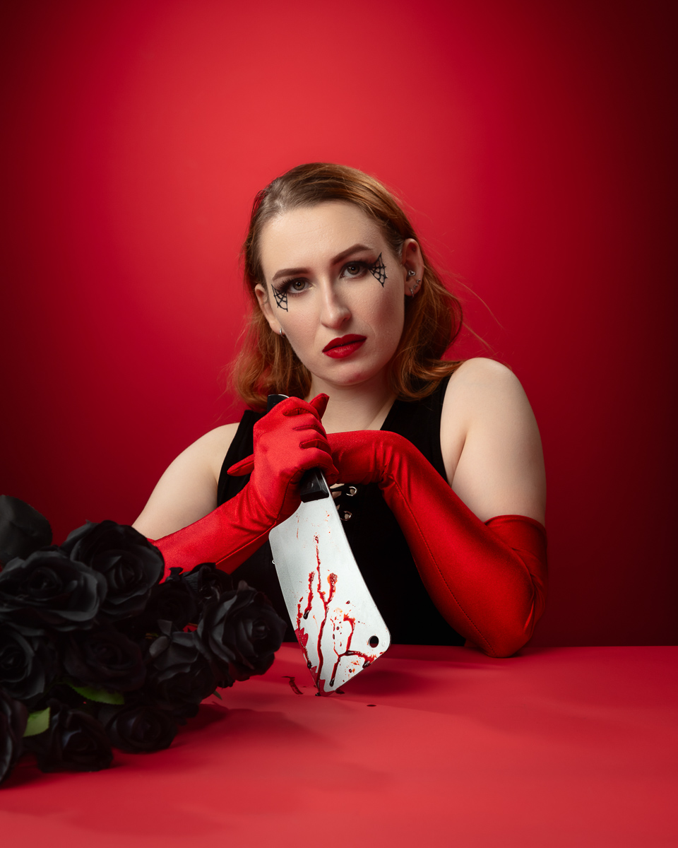 Woman in red gloves holding bloodstained handkerchief against red background