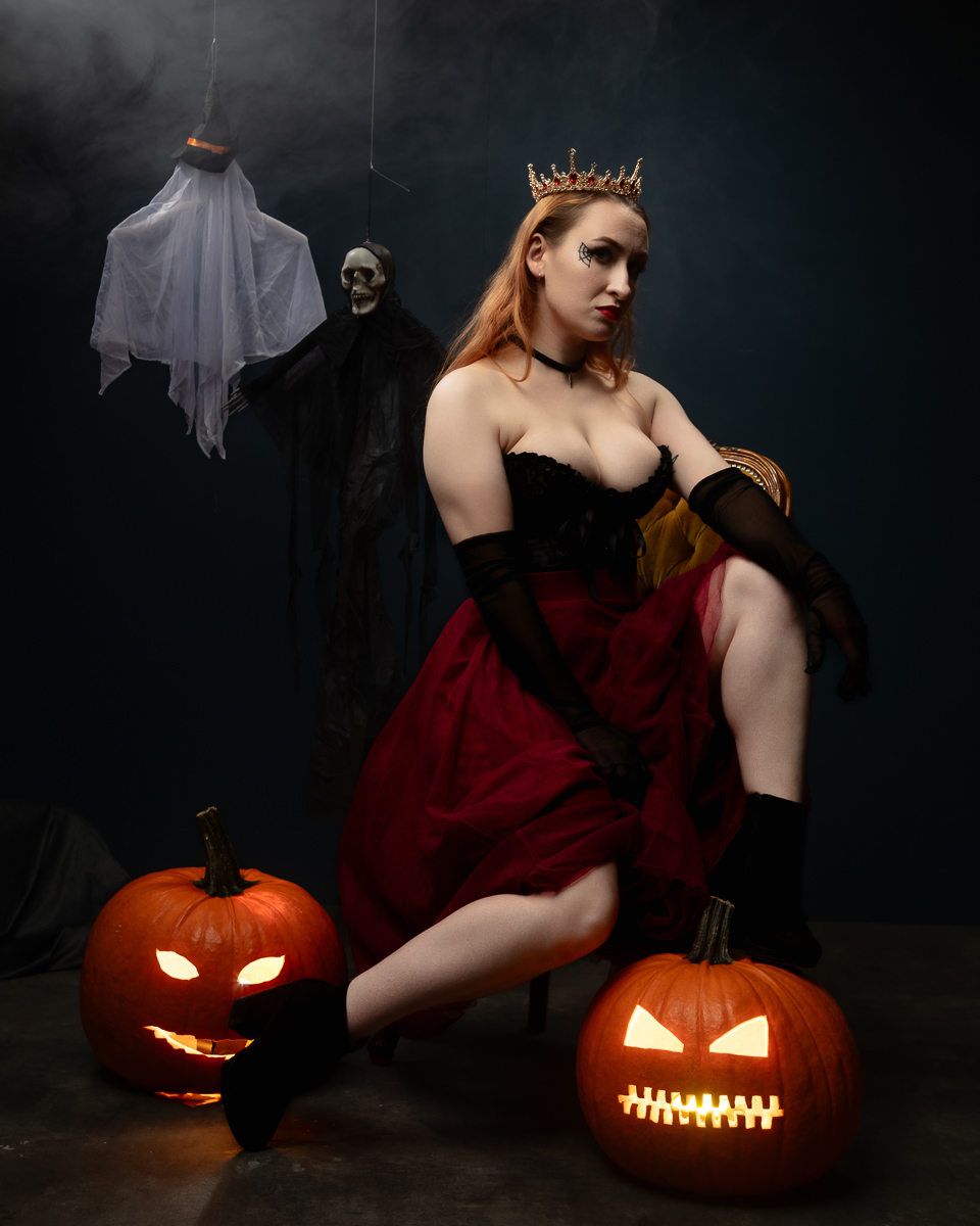 Woman wearing crown with Halloween pumpkins and skeletal figures