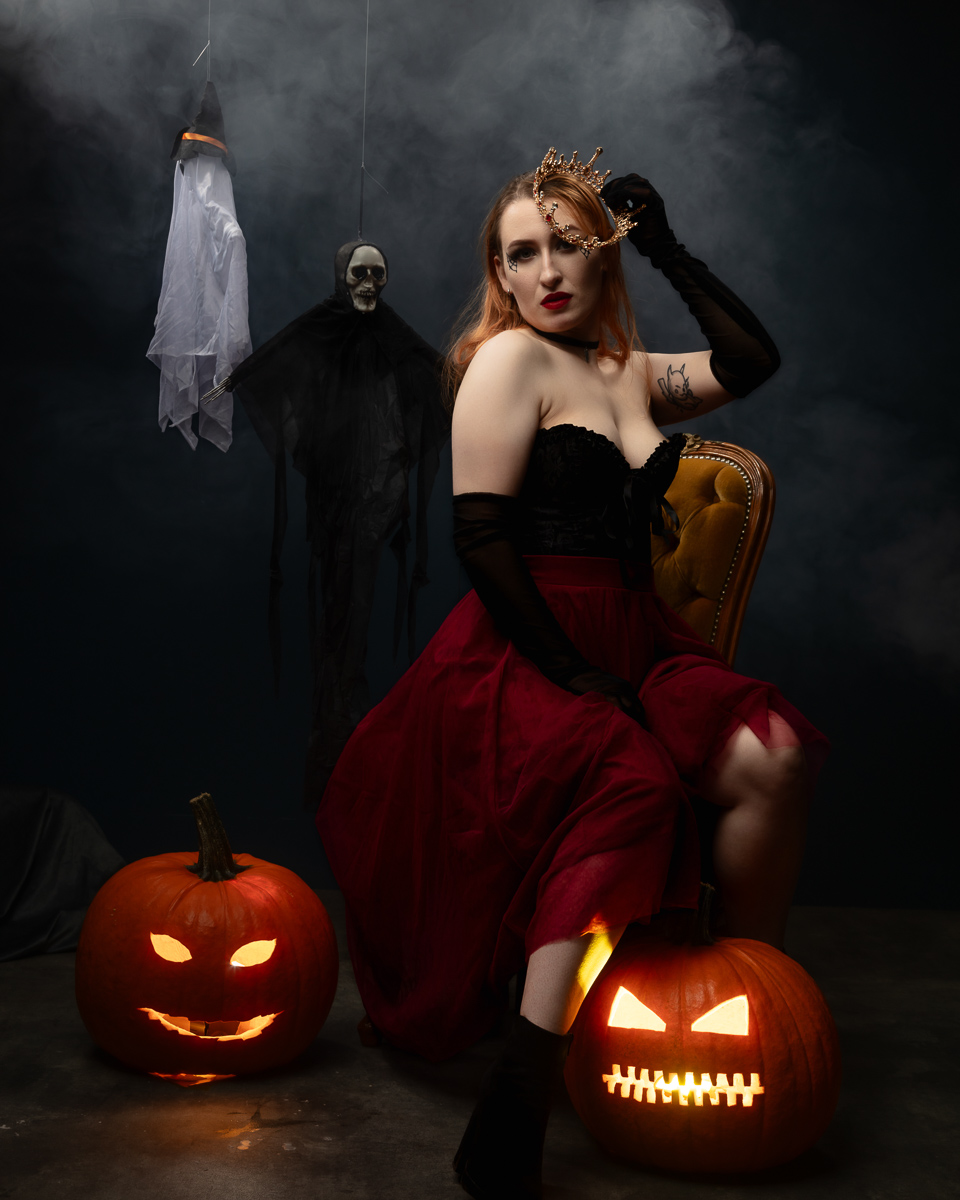 Woman in gothic Halloween costume with glowing jack-o'-lanterns