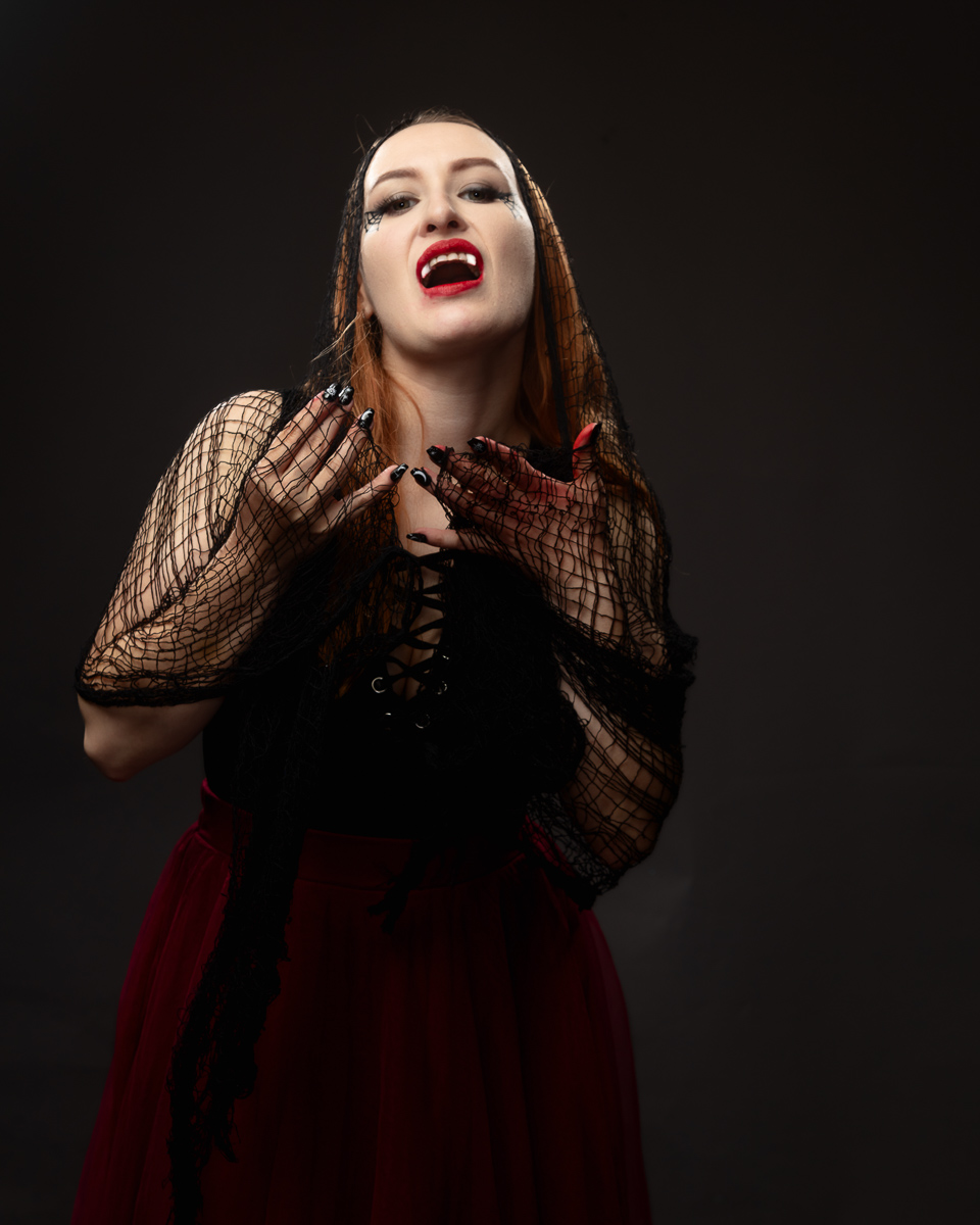 Woman with red lipstick wearing gothic black and red dress