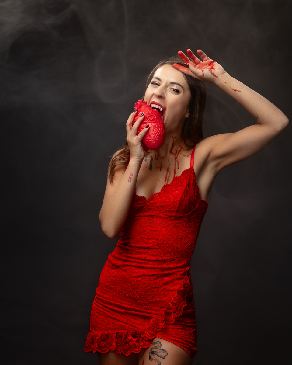 Woman in red dress holding decorative heart prop