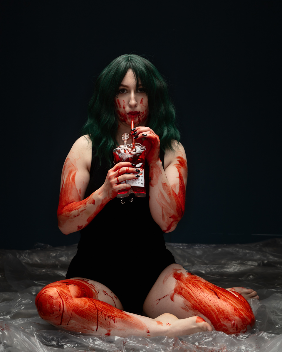 Woman with dark hair holding red liquid bottle artistic portrait