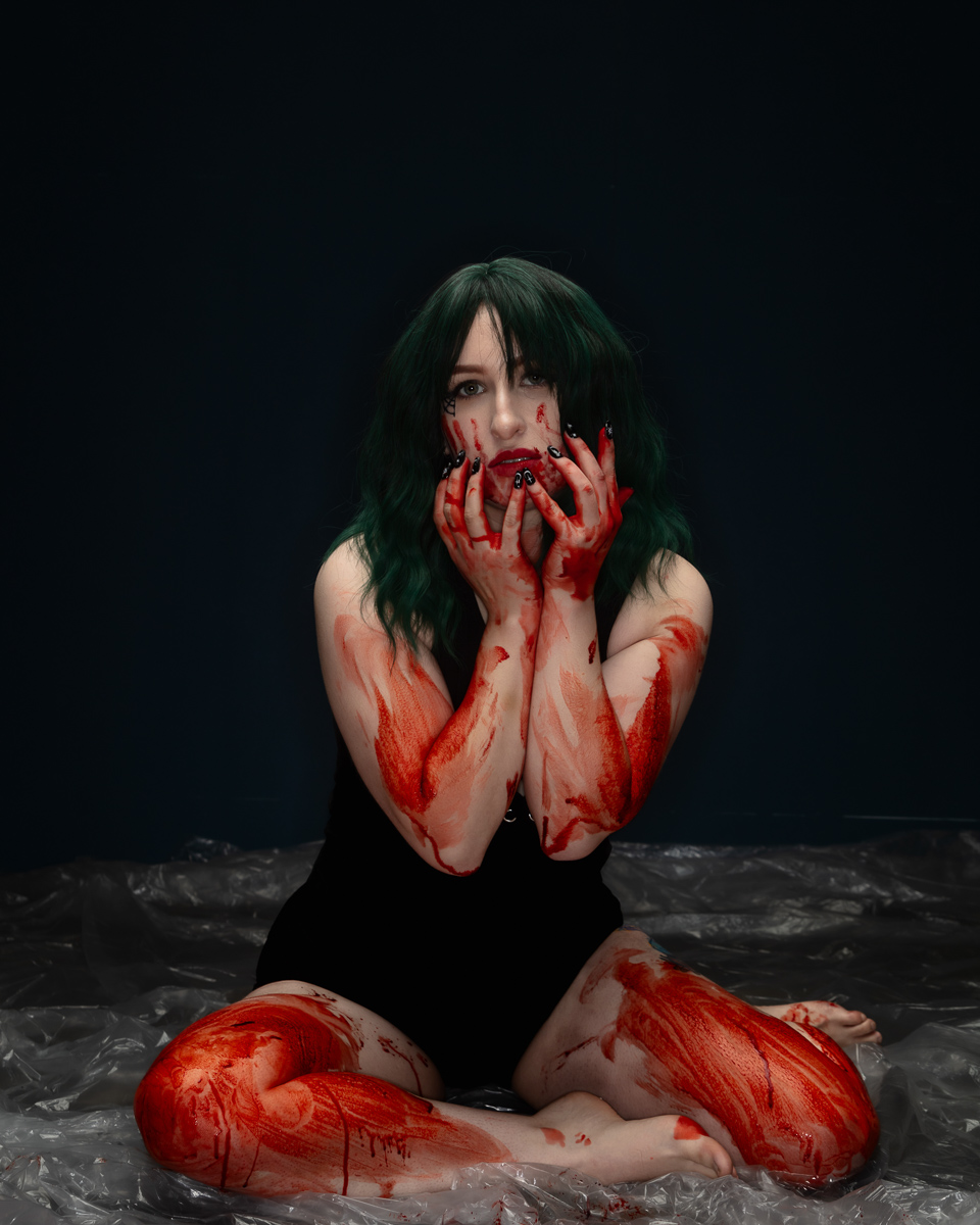 Woman with dark hair covered in red paint artistic portrait