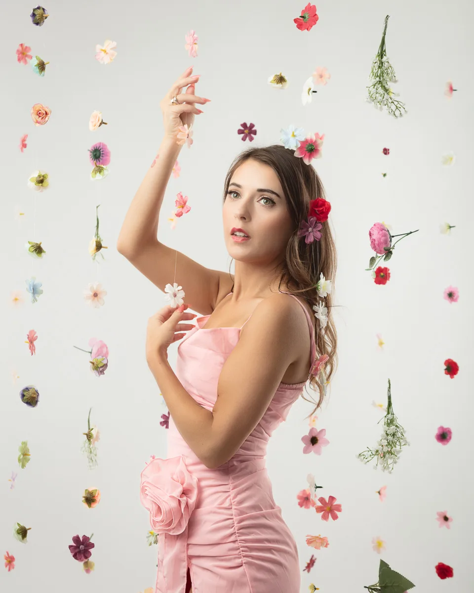 Woman in pink dress surrounded by colourful flowers