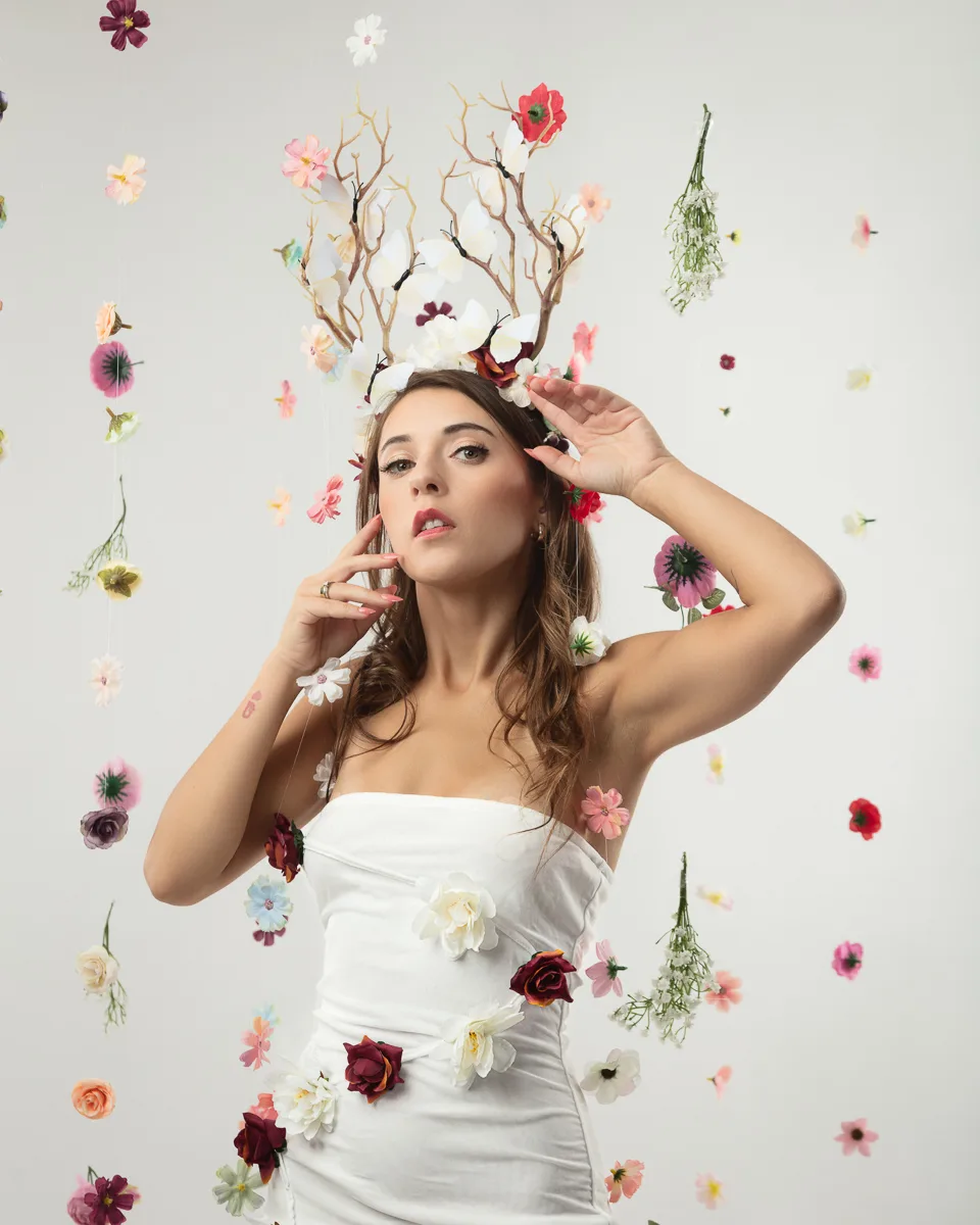 Woman in white dress surrounded by colourful flowers