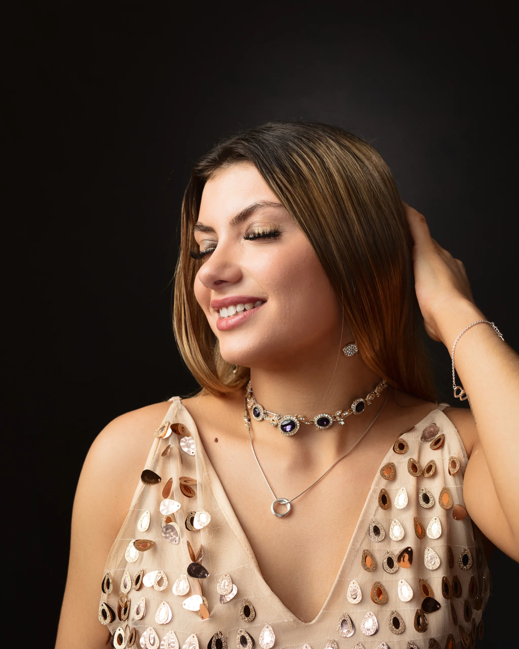 Woman smiling in elegant dress with jewellery.