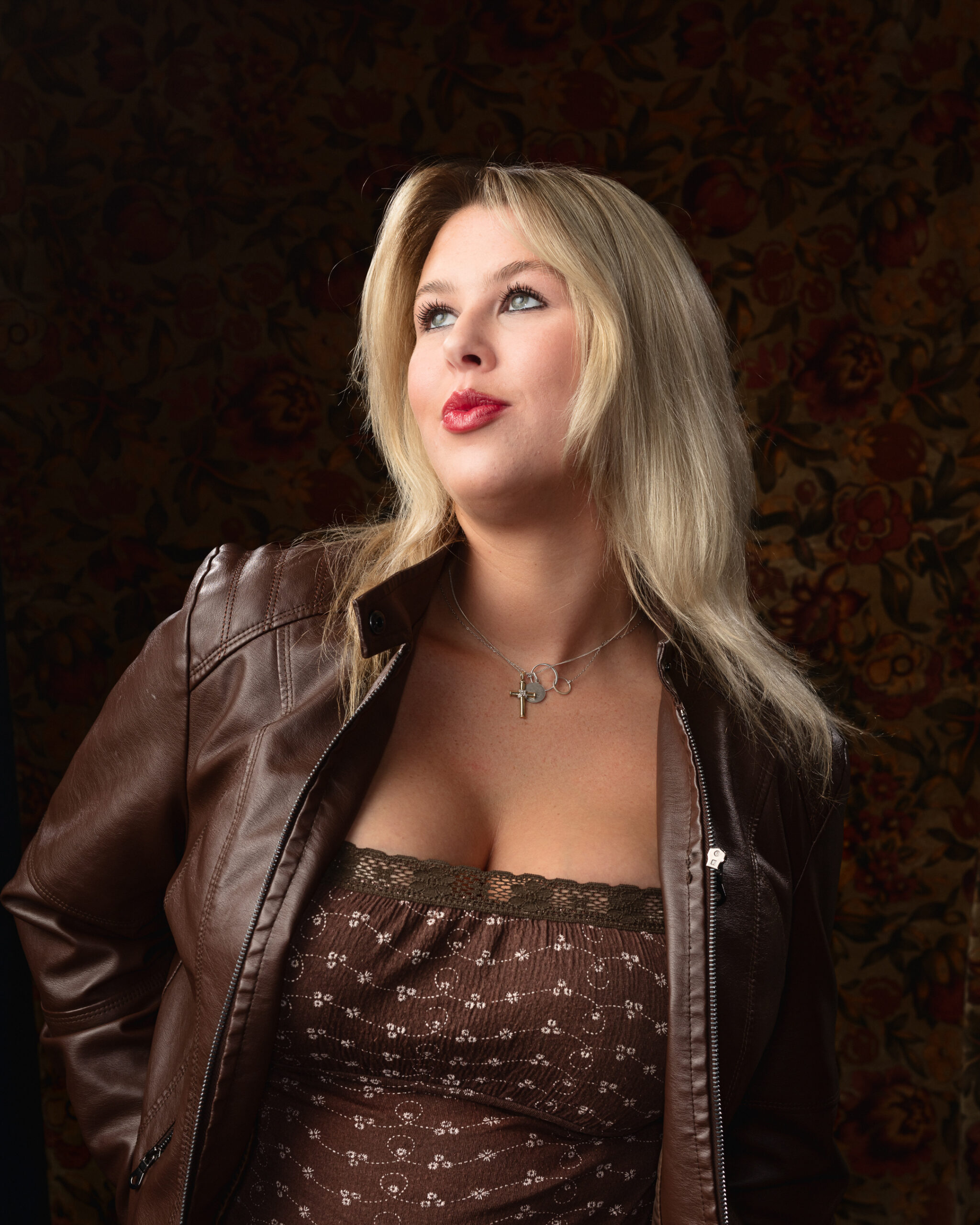 Woman in brown leather jacket and floral background