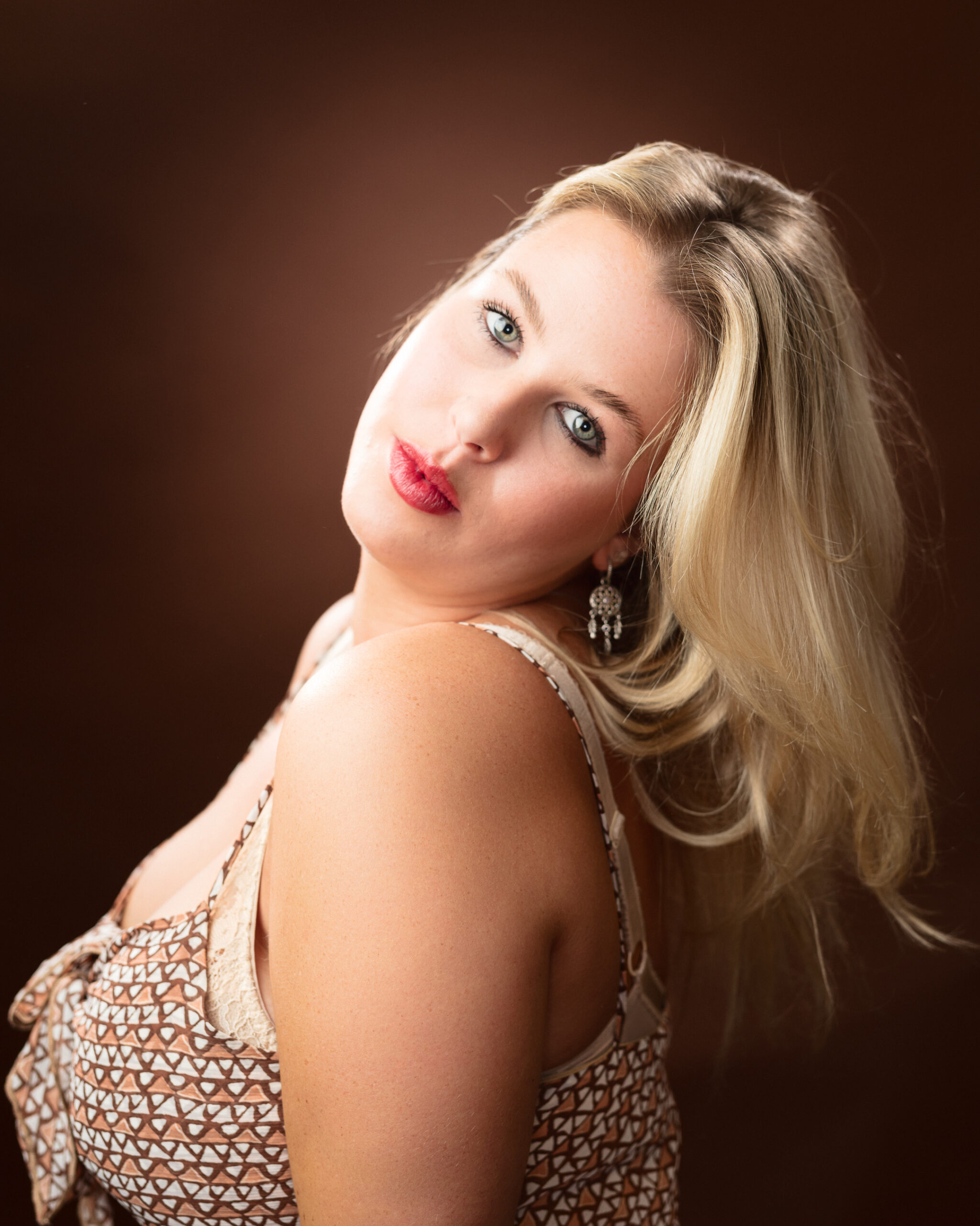 Woman posing with long blonde hair and red lips.