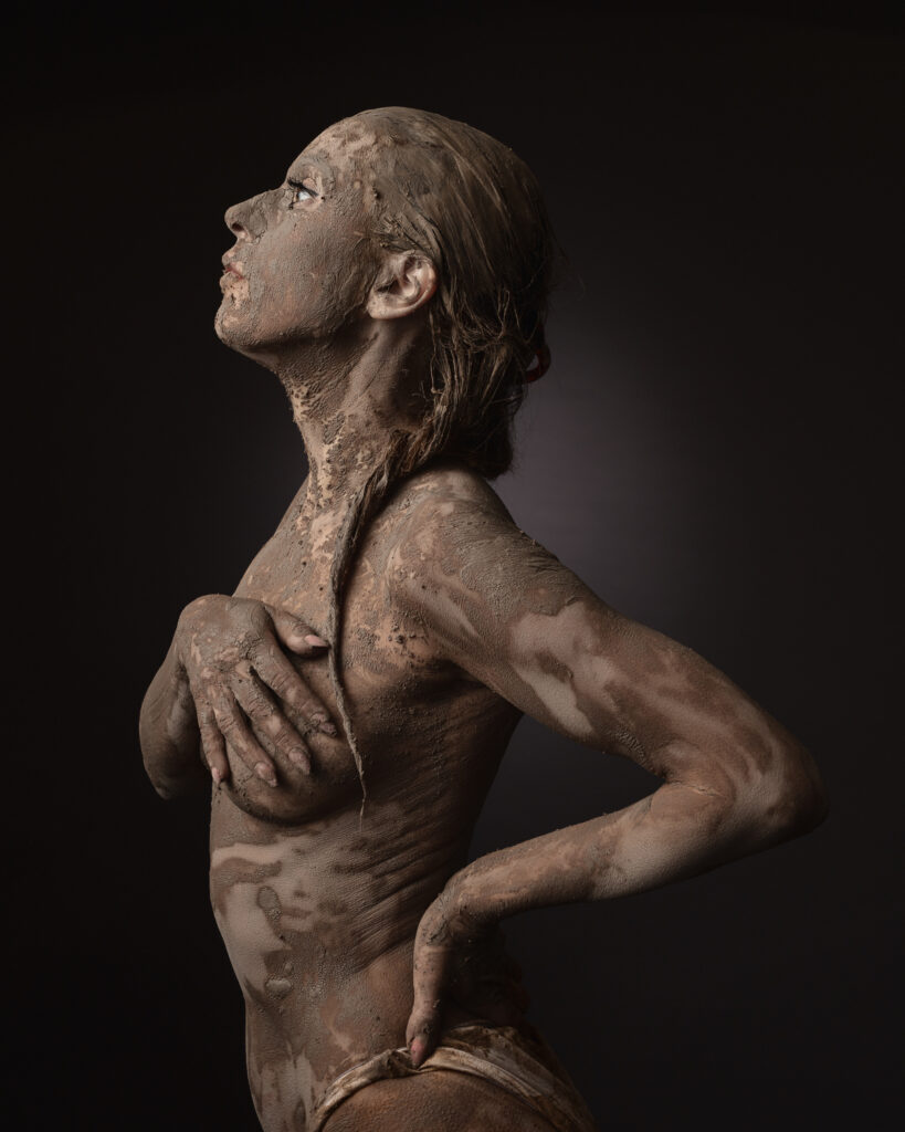 Side profile of person covered in mud.