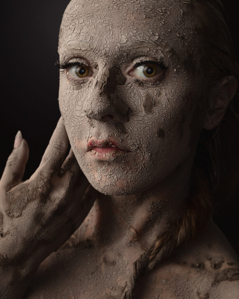 Face covered in cracked clay mask