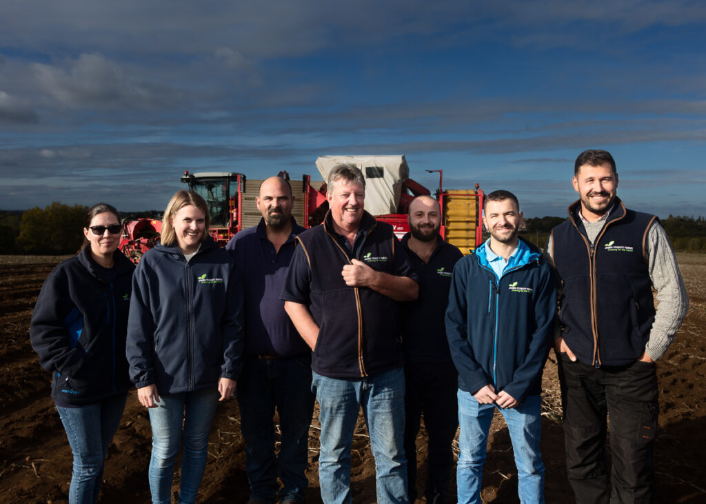 Group of farmers in a field with equipment.