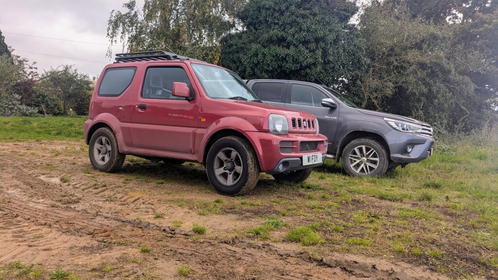 Red and grey SUVs parked on grassy field.