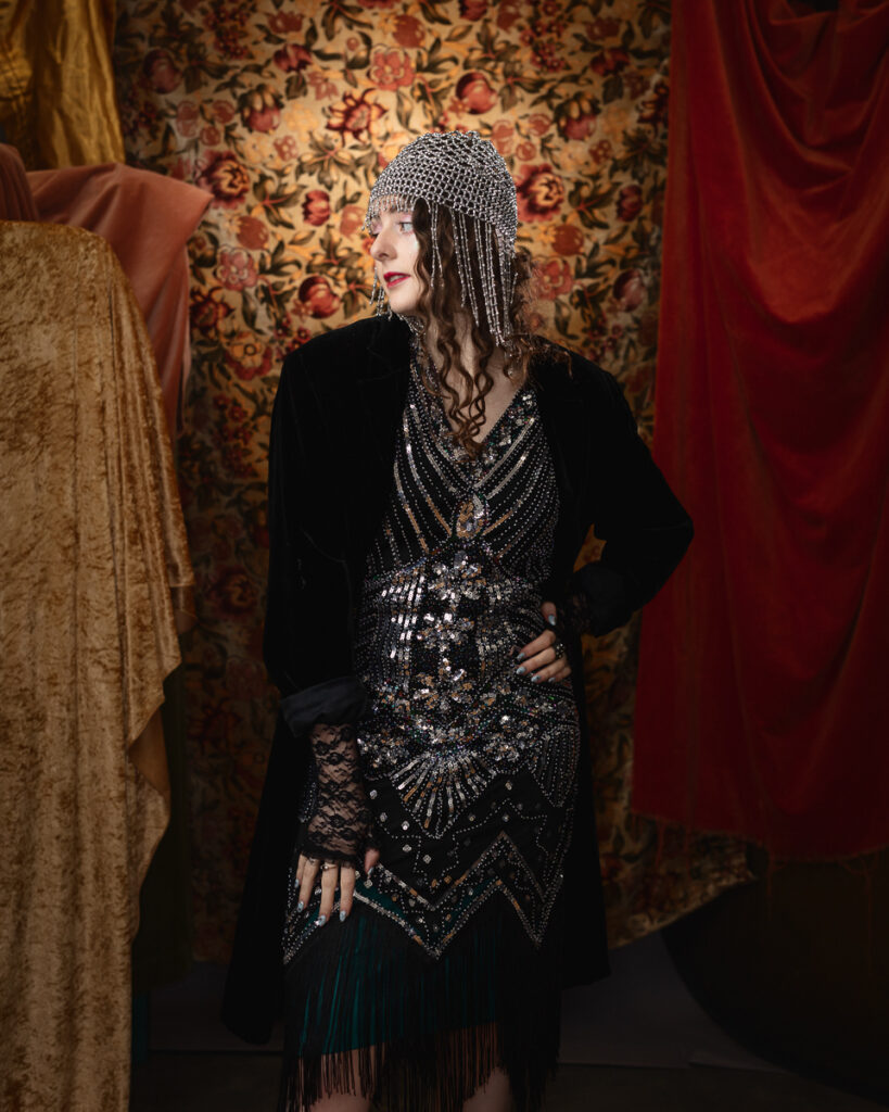 Woman in ornate dress with floral backdrop