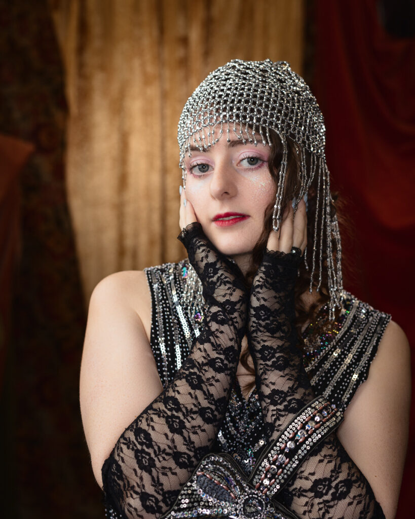 Woman in embellished costume and lace gloves.