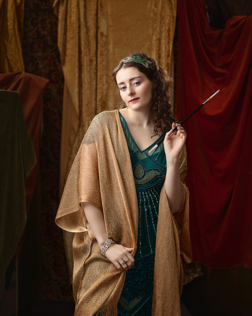 Woman in vintage dress holds cigarette holder