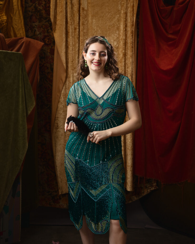 Woman in green flapper dress holding fan