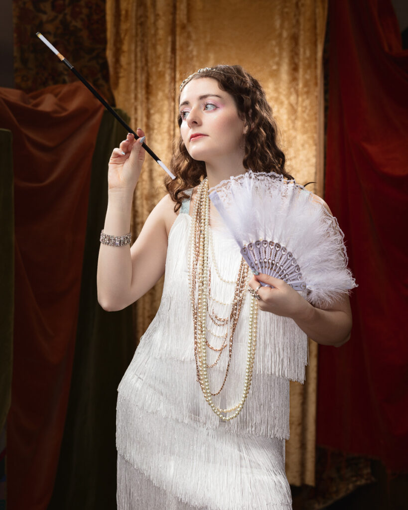 Woman in vintage flapper dress with fan.