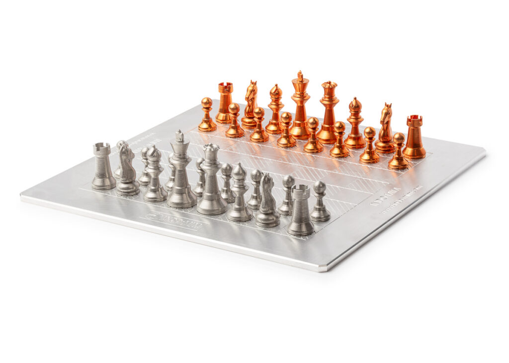 Product photograph of a metal chess set with copper and silver pieces