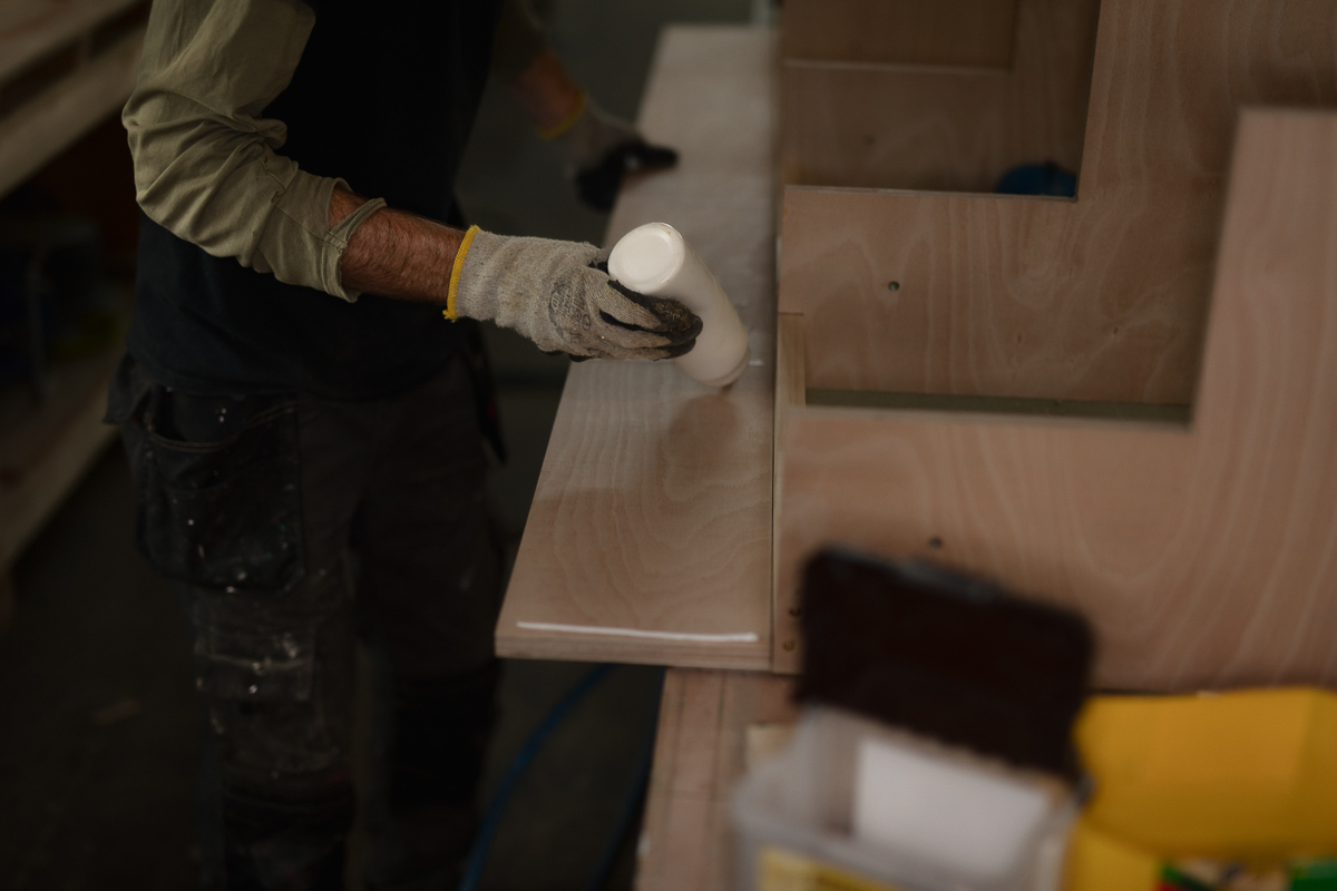 Woodworker applying glue to wooden board