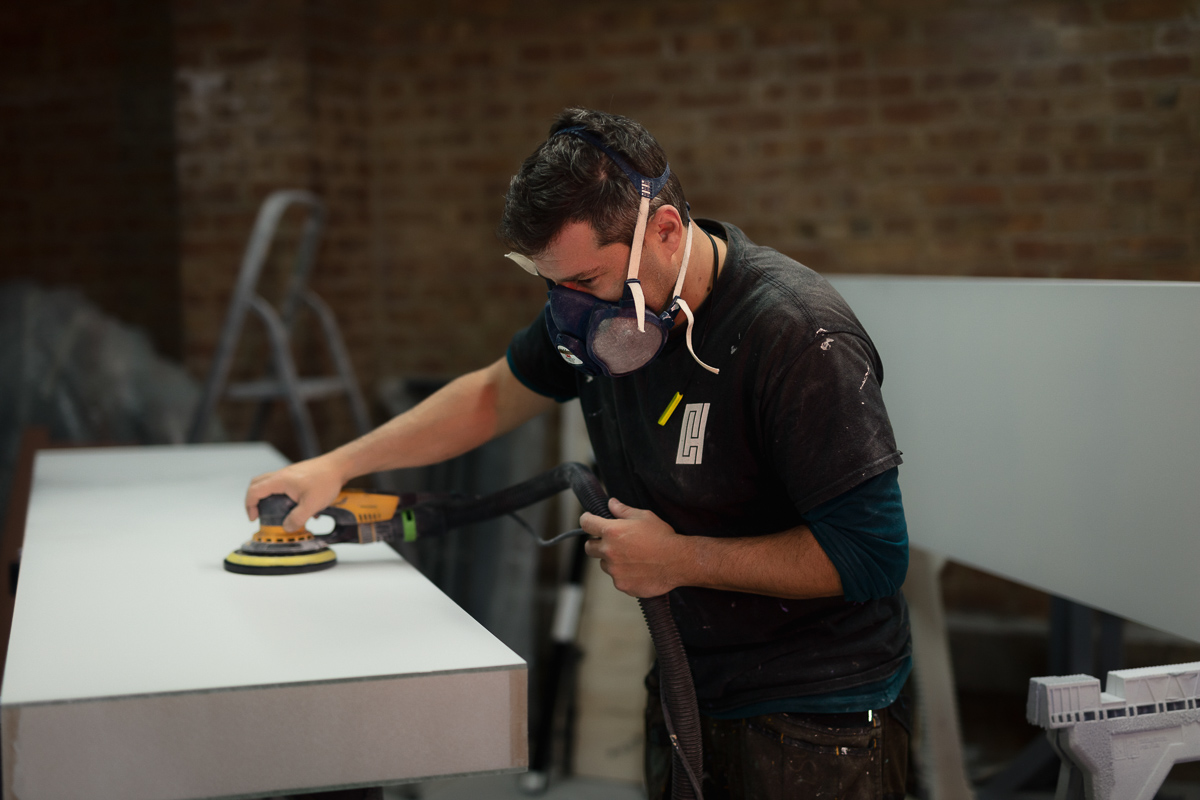 Worker sanding a surface in workshop