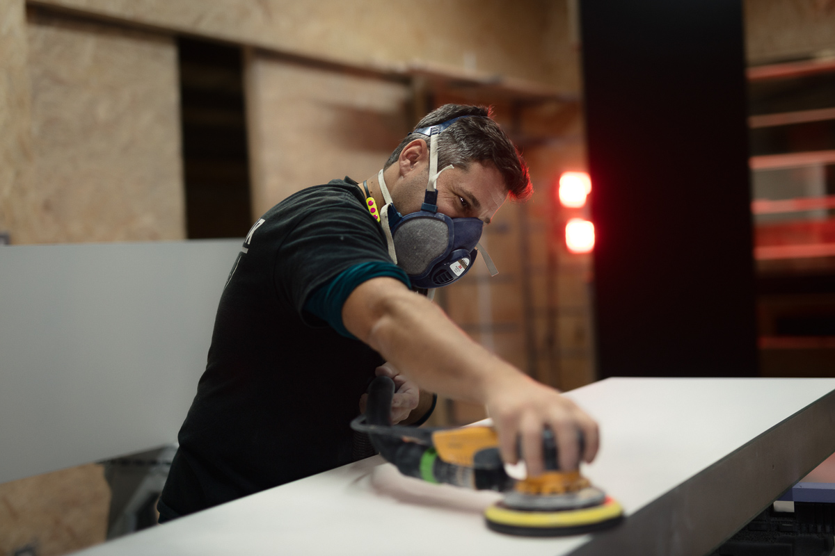 Man sanding wood with protective mask.