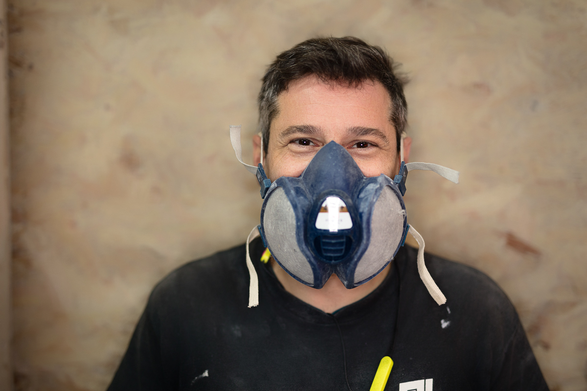 Man wearing a dust mask in a workshop, photographed for Coldharbour Industries