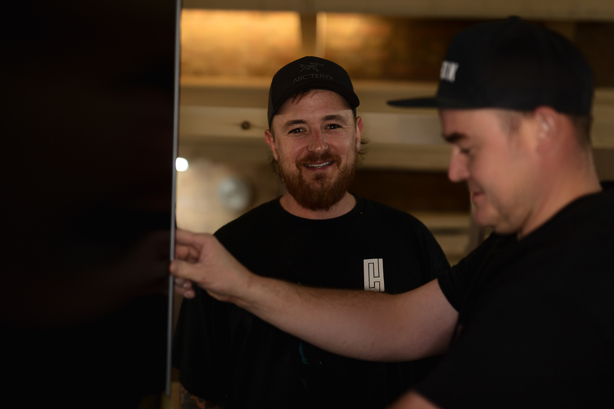Two men working together, smiling.