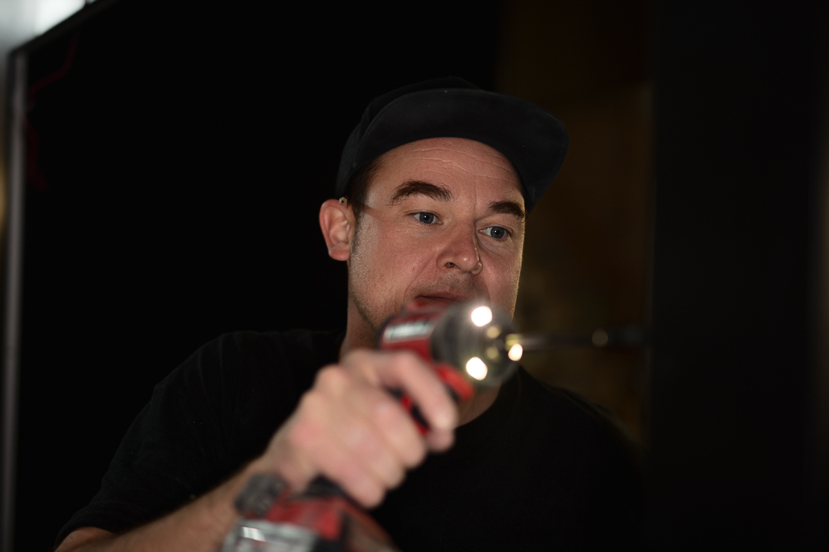 Person using a power drill, focused on task.
