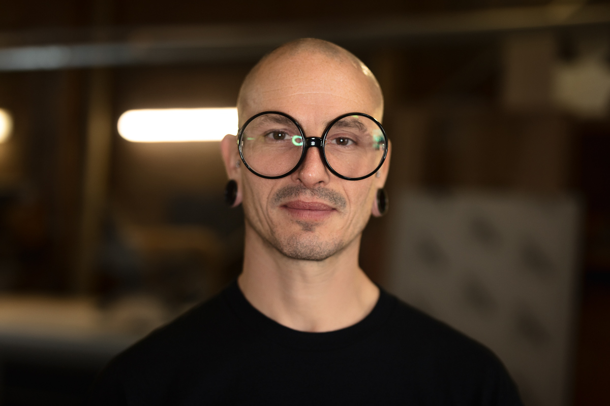 Person wearing oversized round glasses, indoors.
