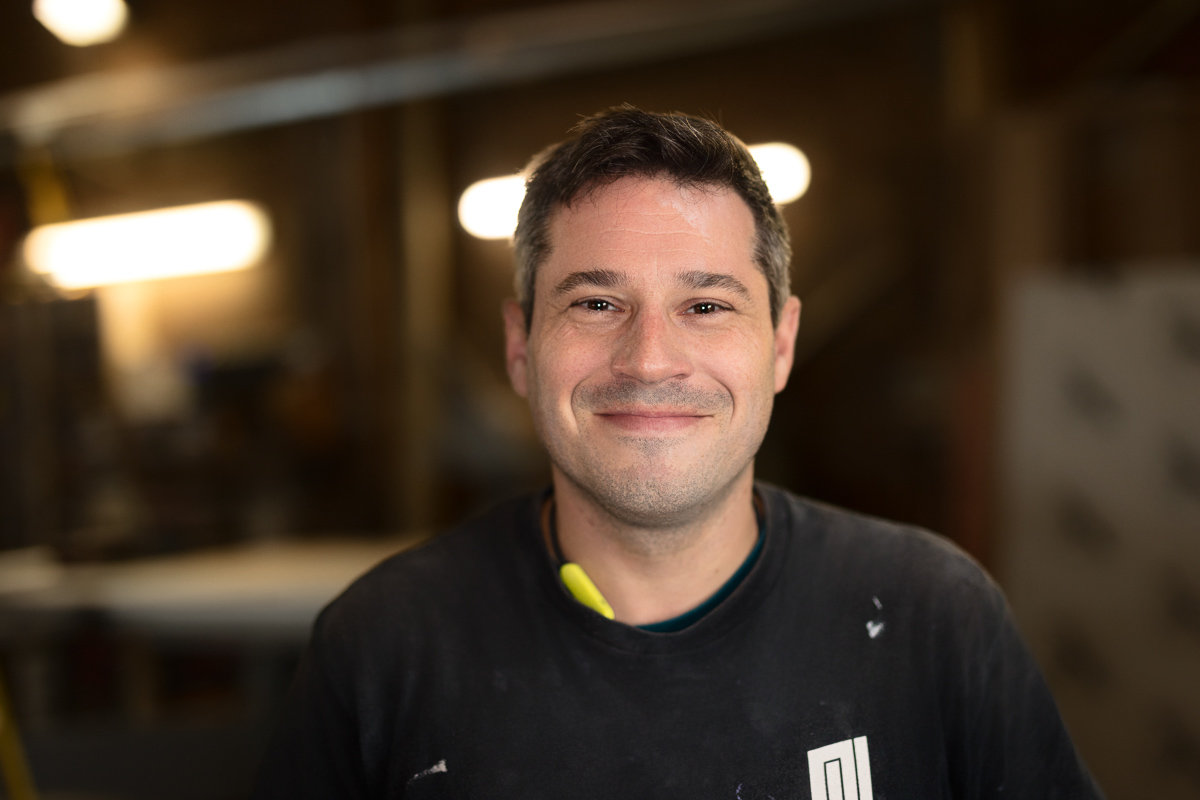 Smiling person in workshop environment.