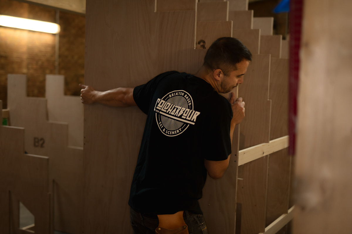 Man assembling wooden panels indoors.